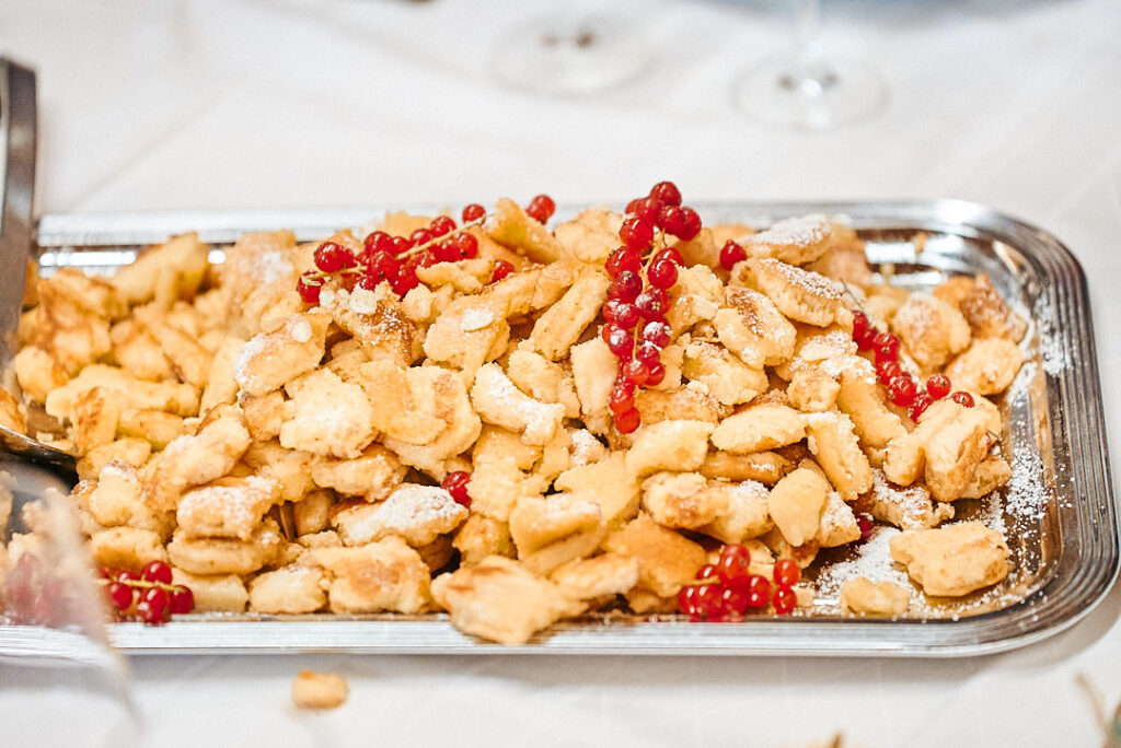 Kaiserschmarrn mit Puderzucker und roten Johannisbeeren auf einer Servierplatte an der Floßlände in Augsburg